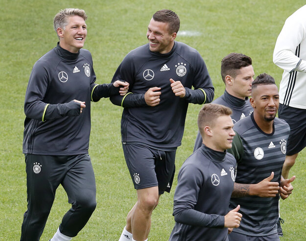 Nemeckí hráči Bastian Schweinsteiger (vľavo) a Lukas Podolski (v strede) na tréningu.