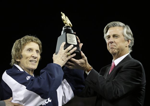 Mike Ilitch (vľavo) a generálny manažér bejzbalového tímu Detroit Tigers Dave Dombrowski dvíhajú na snímke z 18. októbra 2012 Trofej Williama Harridgea po víťazstve nad New Yorkom Yankees.