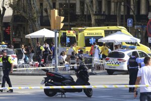 Záchranári ošetrujú zranených ľudí po teroristickom útoku autom na ulici La Rambla v Barcelone.