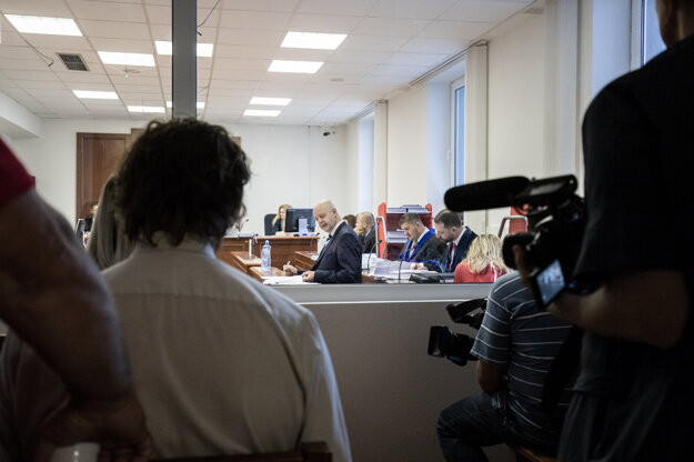 Novinári sledujú súdne pojednávanie.