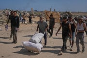 Palestínčania nesú balíčky s humanitárnou pomocou v blízkosti distribučného centra Nadácie pre humanitárnu pomoc v Gaze.