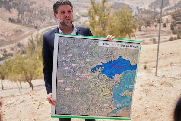 Izraelský krajne pravicový minister financií Becalel Smotrič drží mapu, ktorá zobrazuje výstavbu novej štvrte osady Ma'ale Adumim v takzvanej zóne E1.