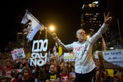Demonštrant má na tvári masku s podobizňou izraelského premiéra Benjamina Netanjahua počas protestu izraelskej vláde, na ktorom žiadali prepustenie rukojemníkov zadržiavaných v Pásme Gazy v Tel Avive.