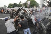 Ľudia prevracajú vrak auta, spálené počas násilných protestov proti zákonodarným príspevkom a policajnej brutalite počas stretov medzi poriadkovou políciou a študentskými protestujúcimi v Jakarte 30. augusta. 
