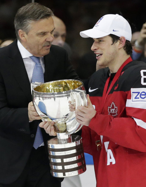Na snímke zo 17. mája 2015 odovzdáva René Fasel trofej za víťazstvo na majstrovstvách sveta v Česku kapitánovi Kanady Sidneymu Crosbymu.
