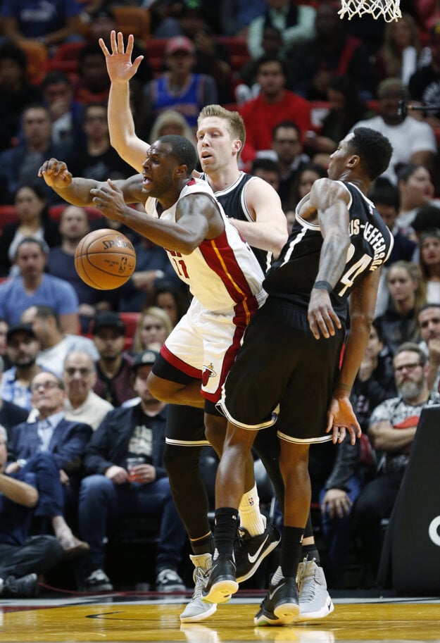 Dion Waiters (v bielom) bojuje o loptu s dvoma hráčmi Brooklynu.