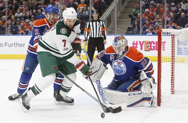 Andrej Sekera (vľavo) napáda pred bránou svojho spoluhráča Cama Talbota útočníka Minnesoty Chrisa Stewarta.