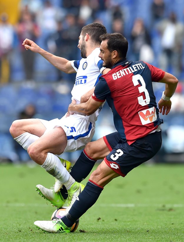 Roberto Gagliardini (vľavo) z Interu Miláno padá po súboji so Santiagom Juanom Gentillettim.