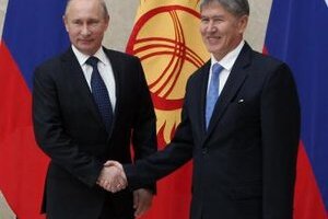 Kirgizský prezident Almazbek Atambajev (vpravo) a ruský prezident Vladimir Putin (vľavo) si podávajú ruky počas stretnutia v Biškeku.