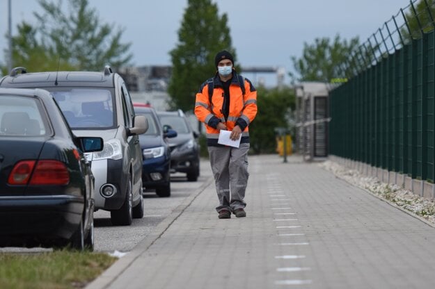 Zamestnanec koncernu Groupe PSA prichádza do práce po vyznačených bodoch, ktoré sú od seba vzdialené 2 metre v rámci dodržiavania rozostupov v Trnave.