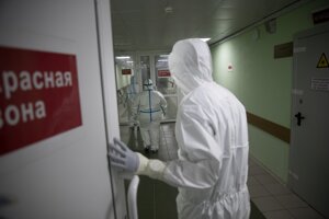 Zdravotný personál v špeciálnych ochranných odevoch kráča chodbou v červenej zóne na jednotke intenzívnej starostlivosti v nemocnici v Moskve.