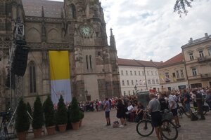 Námestie pri Dóme je poloplné, veriaci, ktorí sa nedostali dovnútra, sledujú slávnostný obrad na veľkoplošnej obrazovke. 