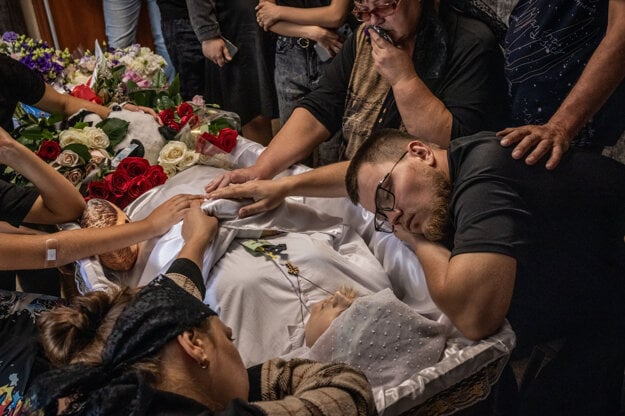 Oleksandr Košyk smúti spolu s ostatnými za svojou tehotnou manželkou Dianou pred jej pohrebom v ukrajinskej dedine Auly neďaleko Kamianskeho. (zdroj: Ed Ram — The Washington Post)