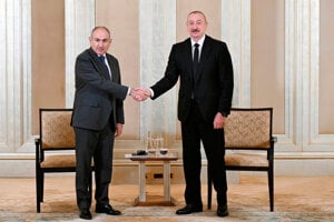 Azerbajdžanský prezident Ilham Alijev (vpravo) a arménsky premiér Nikol Pašinjan si podávajú ruky pred ich rozhovormi v Abú Zabí 10. júla 2025.