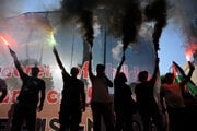 Propalestínski demonštranti zapaľujú svetlice v gréckom prístave Pireus pri príchode izraelskej lode.