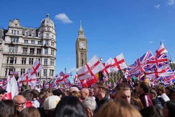 Ľudia demonštrujú počas pochodu a zhromaždenia „Unite the Kingdom“, ktoré v Londýne viedol Tommy Robinson.