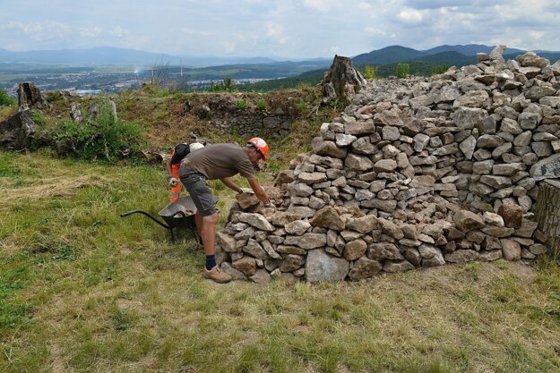 Nezamestnaní pri triedení kameňa pre stavebnú sanáciu.