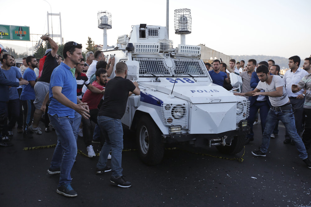 Ľudia sa snažia zastaviť policajné vozidlo, ktoré preváža vojakov zapojených do pokusu o prevrat.