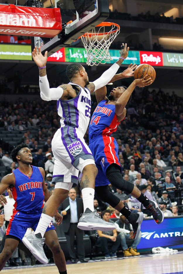 Na kôš zakončuje Ish Smith z Detroitu (vpravo), zablokovať jeho pokus sa pokúša Ben McLemore.