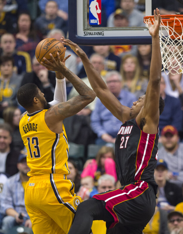 Hráč Miami Hassan Whiteside (vpravo) sa pokúša zablokovať zakončenie Paula Georgea z Indiany.