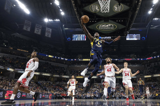Victor Oladipo (v strede) z Indiany smečuje v zápase proti Chicagu.
