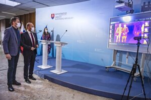 Predseda vlády SR Igor Matovič a  minister obrany SR Jaroslav Naď pred termokamerou sledujú svoju telesnú teplotu.