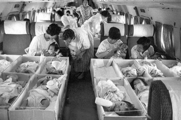 Úradníci súkromnej adopčnej agentúry v decembri 1956 ukladajú do lietadla deti určené na adopciu.