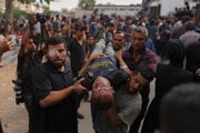 muži nesú telo mladého Palestínčana Mohammeda Al-Matouqa, ktorý zomrel pri pokuse dostať sa k nákladným autám s pomocou vstupujúcim do severného pásma Gazy cez hraničný priechod Zikim s Izraelom začiatkom augusta.