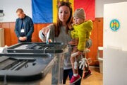 Žena hádže do volebnej urny svoj hlas v parlamentných voľbách v Moldavsku.