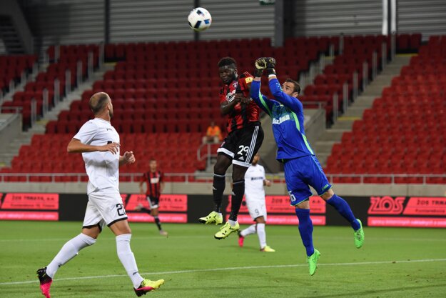 Brankár Hiberniansu Justin Haber boxuje loptu v súboji s hráčom Trnavy Robertom Ndipom Tambem.