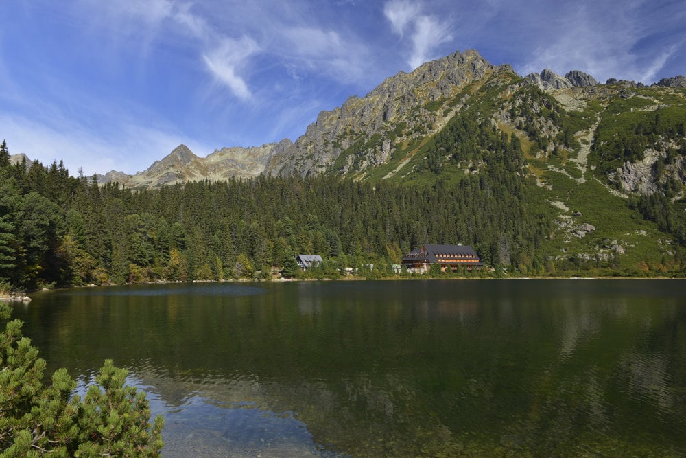 Nad hladinou Popradského plesa je vpravo Horský hotel Popradské pleso a vľavo Majláthova chata. 