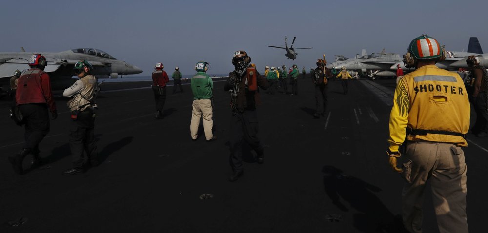 Palubný personál americkej lietadlovej lode USS Dwight D. Eisenhower sleduje štart vrtuľníka. FOTO - TASR/AP