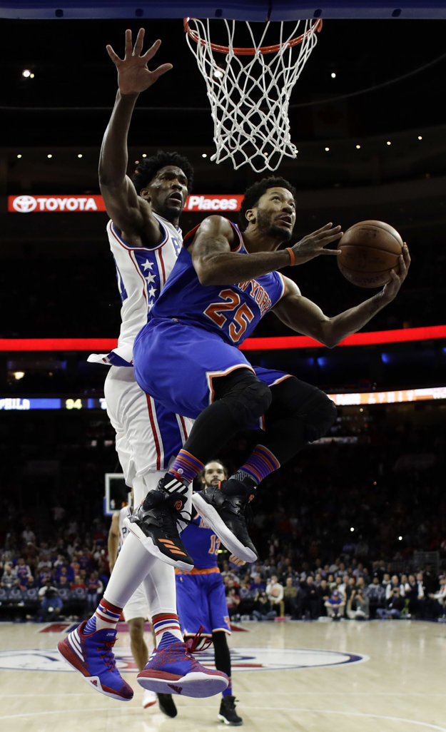 Derrick Rose (vpredu v modrom) z New Yorku zakončuje na kôš v zápase proti Philadelphii. Jeho tímu to však napokon aj tak nepomohlo, keď prehral o jediný bod.