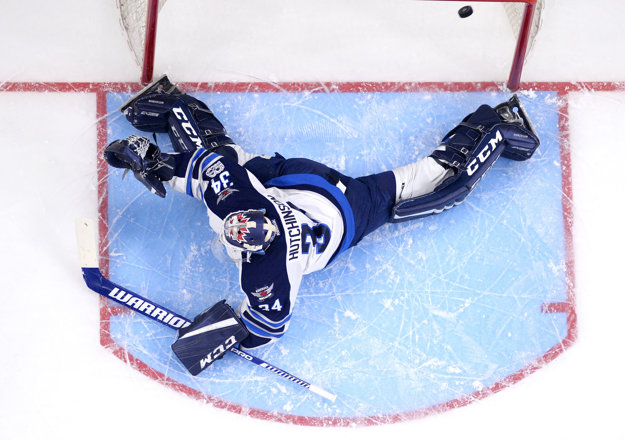 Brankár Winnipegu Jets Michael Hutchinson inkasuje gól po zakončení Mariána Gáboríka.