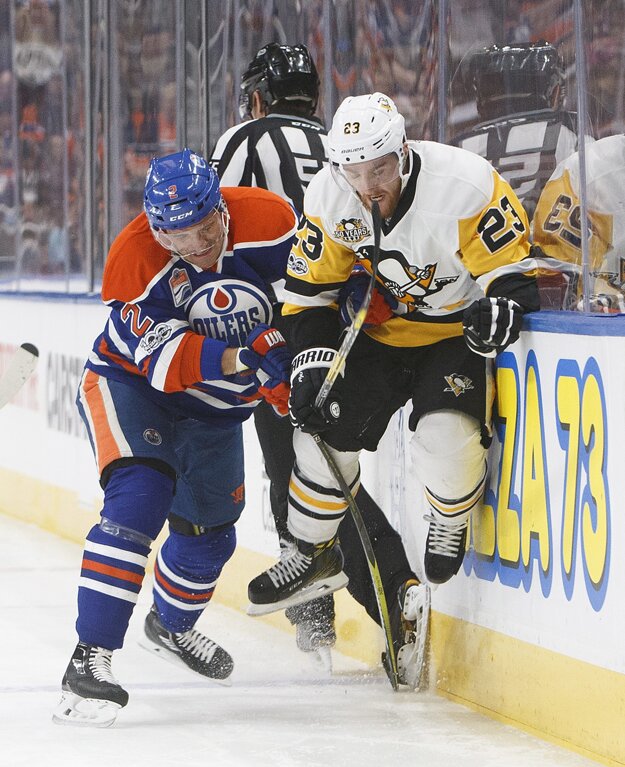 Andrej Sekera (vľavo) vráža na mantinel Scotta Wilsona z Pittsburghu.