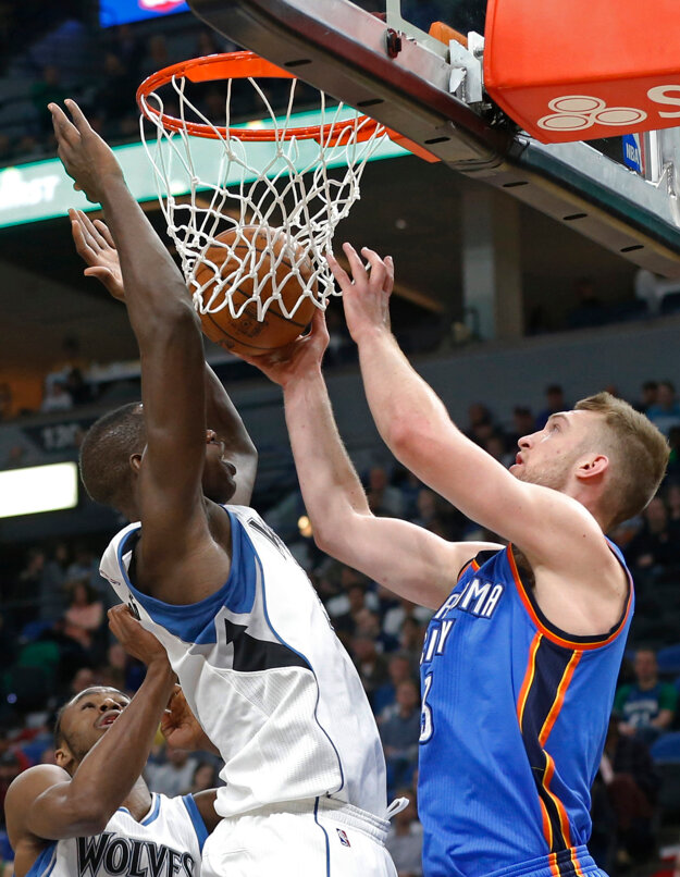 Gorgui Dieng (vľavo) z Minnesoty zakončuje na kôš v zápase proti Oklahome.