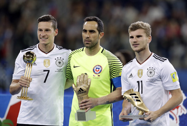 Na snímke trojica najlepších hráčov Pohára konfedrácií - zľava kapitán nemeckého tímu Julian Draxler pózuje so Zlatou loptou pre najužitočnejšieho hráča turnaja, najlepším brankárom sa stal čilský gólman Claudio Bravo a Zlatú kopačku pre najlepšieho strelca získal trojgólový Timo Werner.