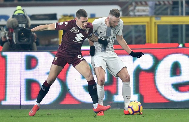 Milan Škriniar (vpravo) bojuje o loptu s hráčom Turína Andreom Belottim.