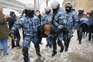 Polícia odnáša demonštranta na proteste v Moskve.