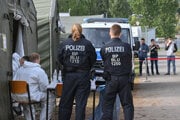 Nemecká polícia čaká na príchod migrantov v centre prijímajúcom žiadateľov o azyl.
