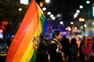 Muž s dúhovou vlajkou počas Pride-u v bolívijskom La Paz.