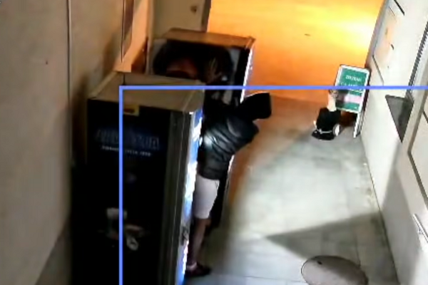 Bezpečnostná kamera zachytáva muža, ktorý sa výrobky z autmatu pokúša dostať násilím. 