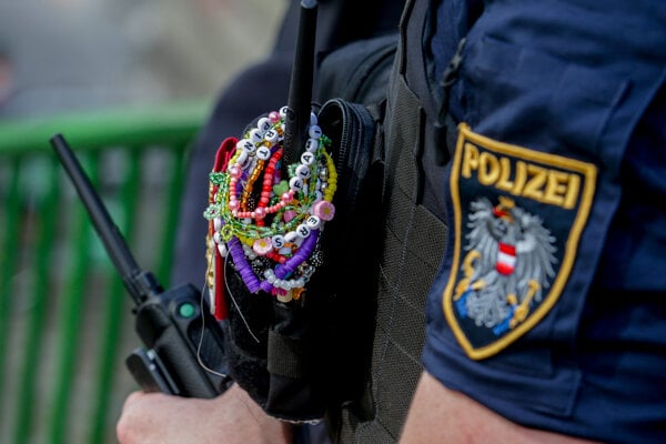 Na archívnej snímke z 8. augusta 2024 policajt je ozdobený náramkami Taylor Swiftovej počas stráženia centra mesta vo Viedni.