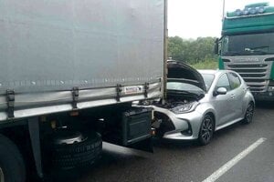 Strieborná Toyota ostala zakliesnená medzi kamiónmi. 