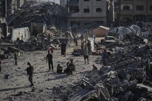 Ľudia pri poškodenej klinike Šejk Radwan al-Taba po bombardovaní mesta Gaza City.