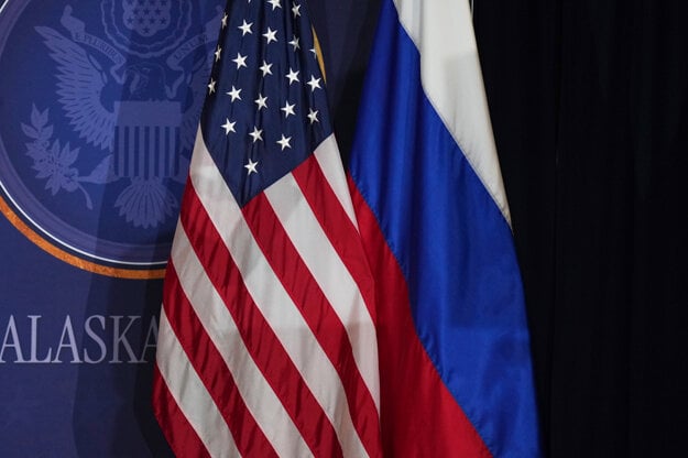 Americká a ruská vlajka na pódiu, kde sa uskutoční tlačová konferencia šéfa Bieleho domu Donalda Trumpa a ruského prezidenta Vladimira Putina na vojenskej základni Elmendorf-Richardson v Anchorage na Aljaške 

​
