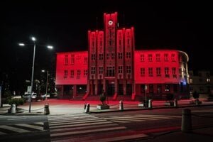 Budova mestského úradu zažiarila červenou farbou. 