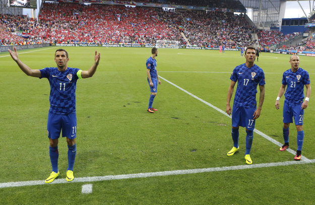 Kapitán Darijo Srna (vľavo) sa snaží upokojiť napätú situáciu na tribúnach v sektore chorvátskych fanúšikov.