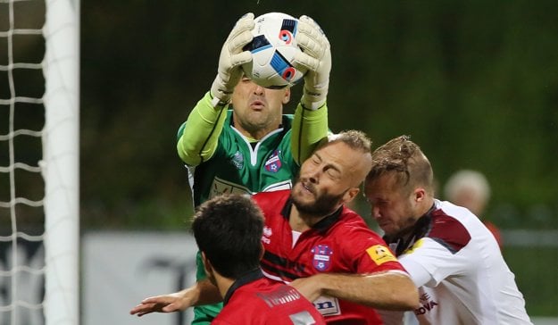 Brankár Zlatých Moraviec Pavel Kováč chytá vo výskoku loptu do svojich rúk.