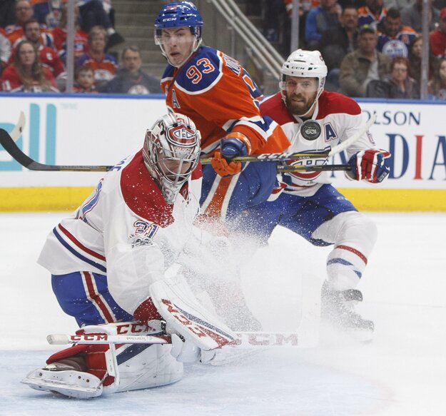 Ryan Nugent Hopkins (v strede) sa pokúša presadiť pred brankárom Montrealu Careym Priceom, bráni ho Shea Weber.